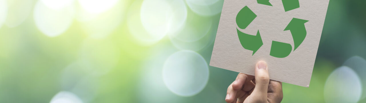 Hand holding recycle symbol on green bokeh background. eco and save the earth concept.